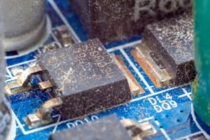 Lähedalt vaadeldes määrdunud elektrooniline kiip trükkplaadil enne ultraheli puhastamist.